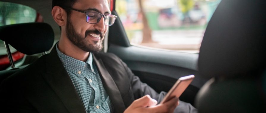 Businessman in the taxi, using a mobile phone on the back seat