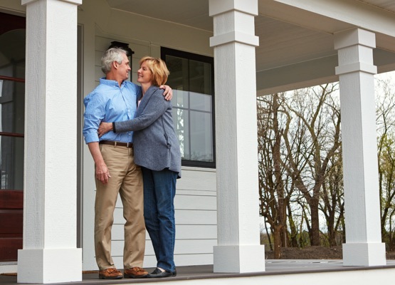 Shot of a happy mature couple standing on the doorstep of their home