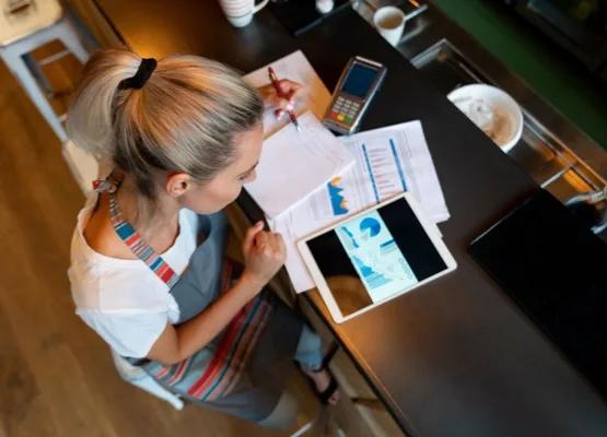 Portrait of a business manager doing the books at a bar using a tablet computer